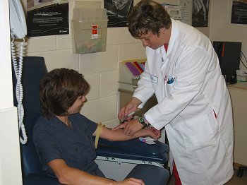 Lab technician performing blood test on patient